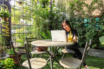 women sitting at a table with her computer working on landscaping designs